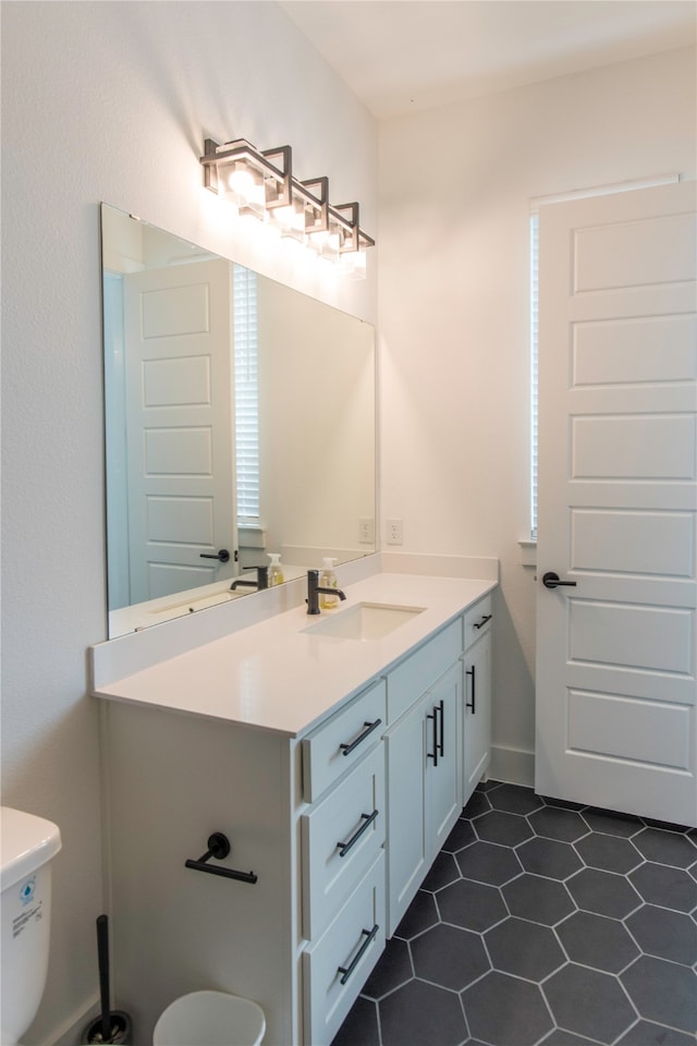 bathroom with tile flooring, vanity, and toilet