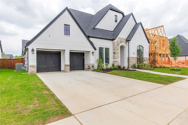 view of front of property with a front lawn, a garage, and central air condition unit