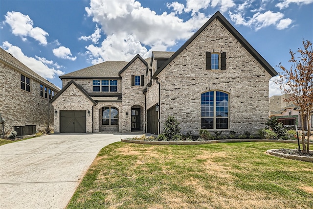 view of front of home featuring a front lawn, a garage, and cooling unit