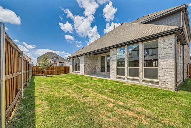 rear view of property with a lawn and a patio