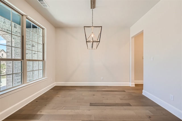 spare room featuring a wealth of natural light and hardwood / wood-style flooring