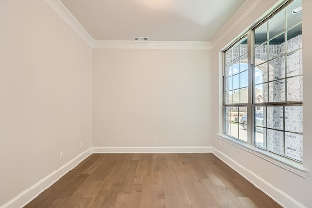 spare room with crown molding and hardwood / wood-style flooring