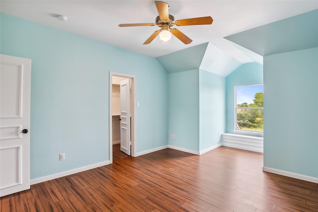 interior space featuring vaulted ceiling, wood-type flooring, a walk in closet, and ceiling fan