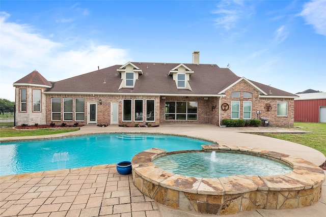 view of pool featuring an in ground hot tub, pool water feature, and a patio