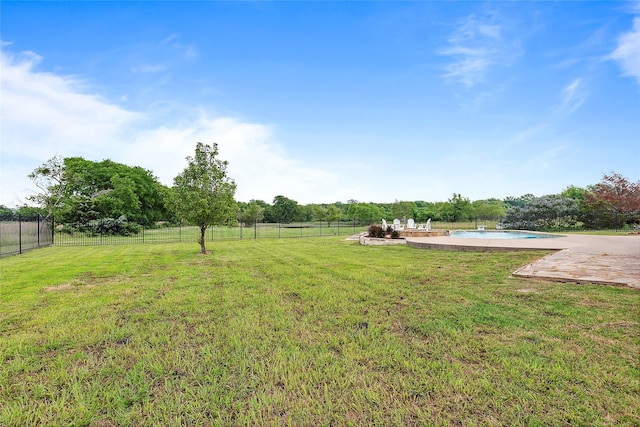 view of yard featuring a fenced in pool, a patio, and a rural view