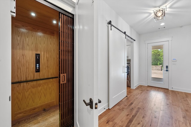 interior space with a barn door and light wood-type flooring