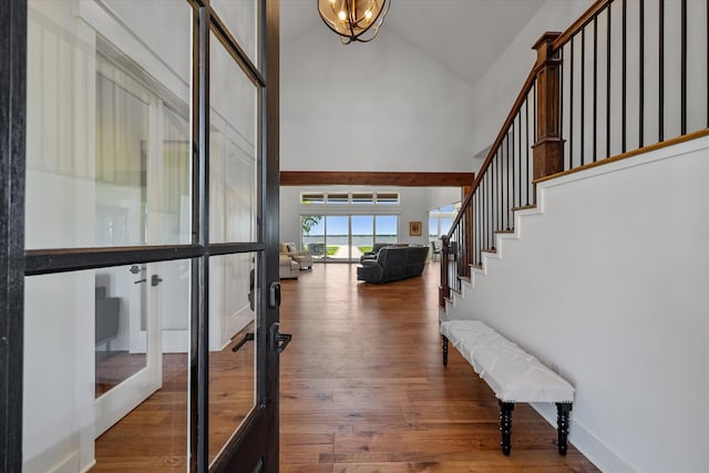 entrance foyer with high vaulted ceiling, french doors, dark hardwood / wood-style floors, and an inviting chandelier