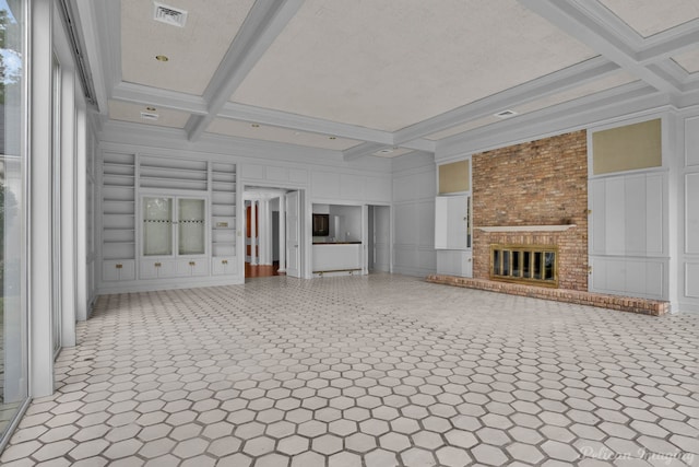 unfurnished living room with beam ceiling, built in features, coffered ceiling, and a brick fireplace