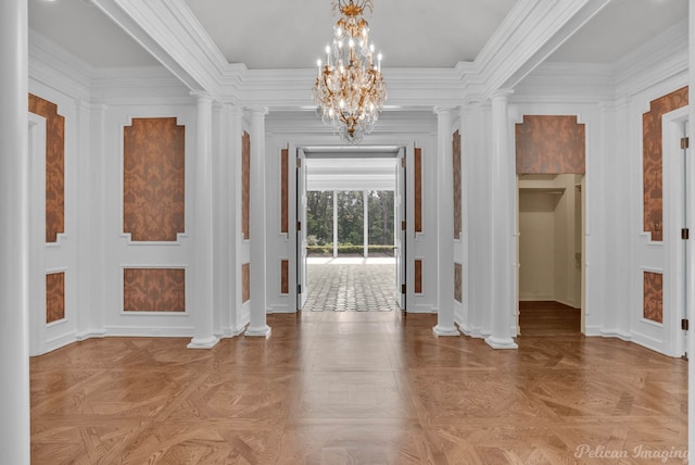 interior space with a notable chandelier, ornate columns, crown molding, and light parquet floors