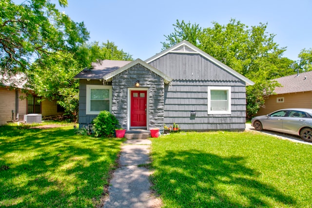 view of front of home featuring central air condition unit and a front lawn