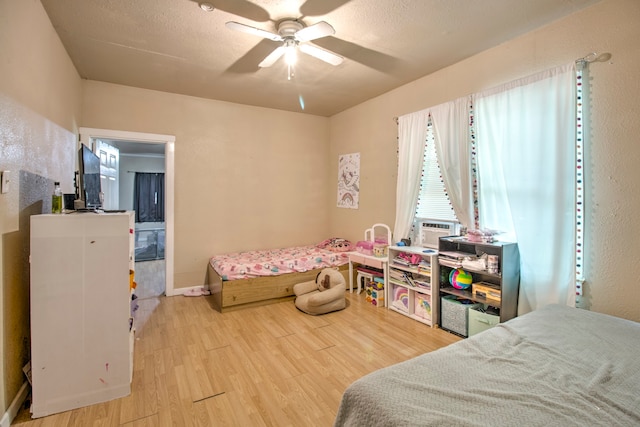 bedroom with ceiling fan, light hardwood / wood-style flooring, and ensuite bath