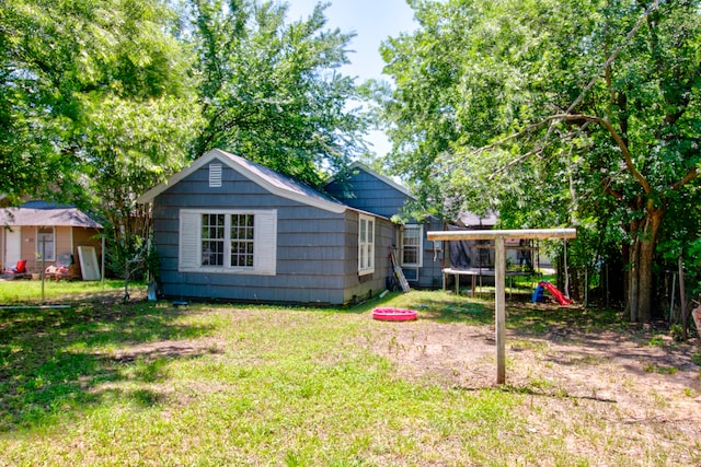 view of yard featuring a playground, a trampoline, and an outdoor structure