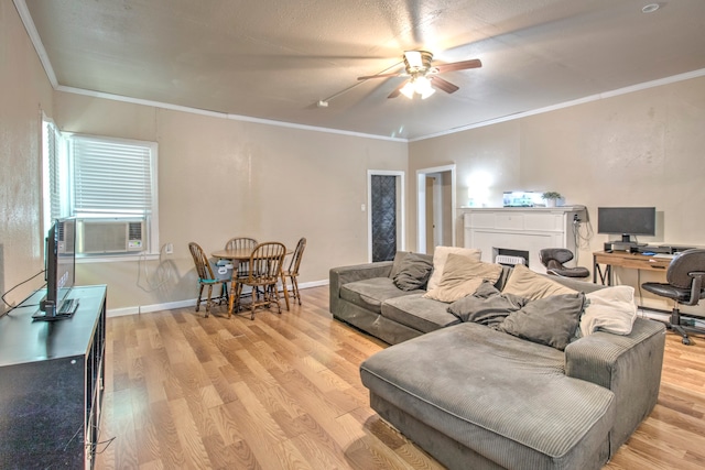 living room featuring ornamental molding, light wood-type flooring, and ceiling fan