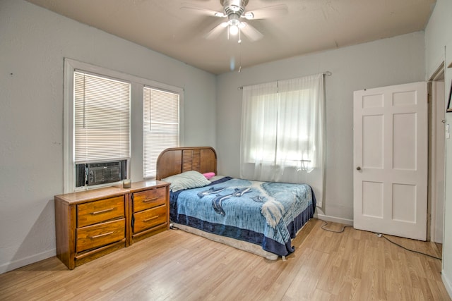 bedroom with ceiling fan, multiple windows, and light wood-type flooring