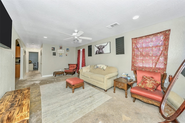 living room featuring a textured ceiling and ceiling fan