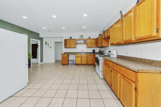 kitchen with white appliances, sink, and light tile patterned floors