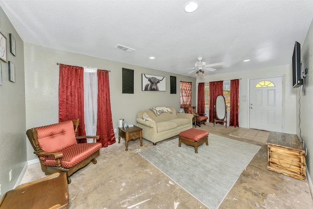 living room featuring a textured ceiling and ceiling fan