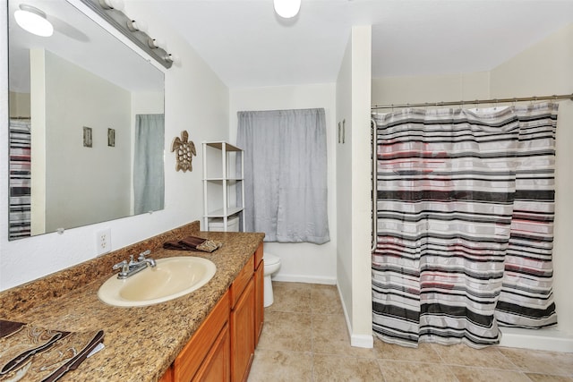 bathroom with tile patterned floors, curtained shower, vanity, and toilet