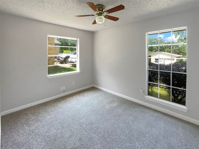 carpeted empty room with ceiling fan and a textured ceiling