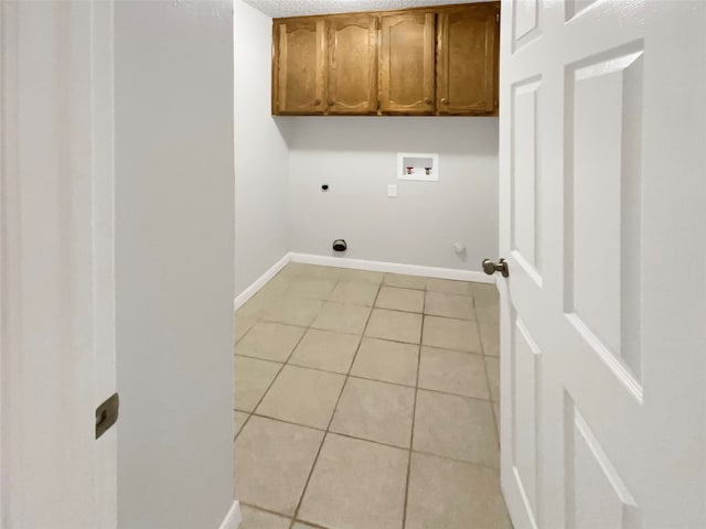 laundry area featuring gas dryer hookup, washer hookup, electric dryer hookup, light tile floors, and cabinets