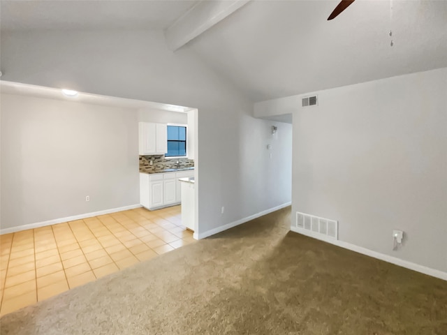 unfurnished living room with light carpet, lofted ceiling with beams, and ceiling fan