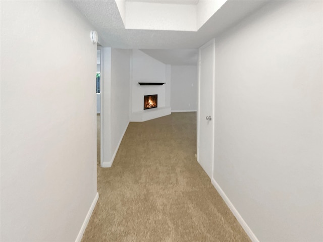 hall with a textured ceiling and carpet floors