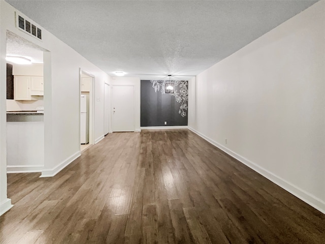 unfurnished living room with a notable chandelier, hardwood / wood-style flooring, and a textured ceiling