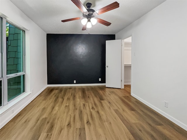 empty room with hardwood / wood-style floors and ceiling fan