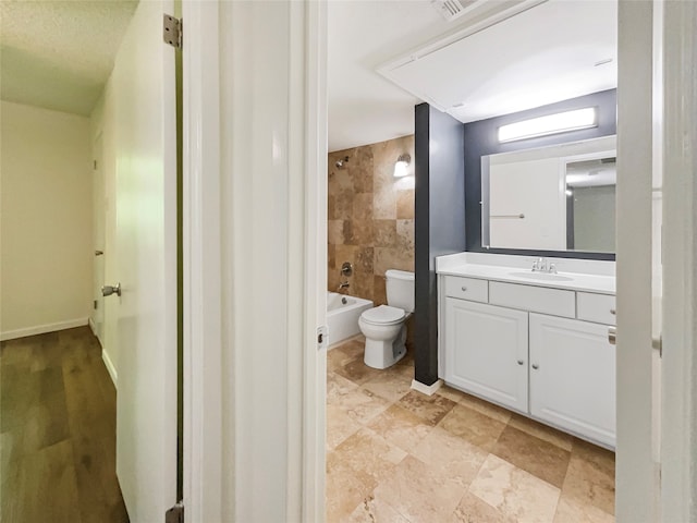 full bathroom featuring tile floors, tile walls, vanity with extensive cabinet space, tiled shower / bath combo, and toilet