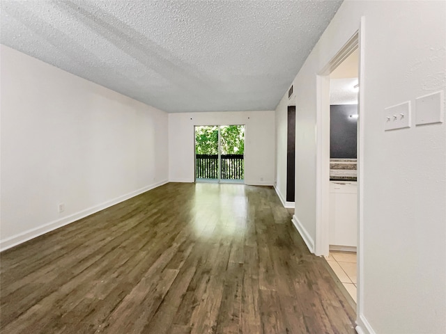 tiled spare room featuring a textured ceiling