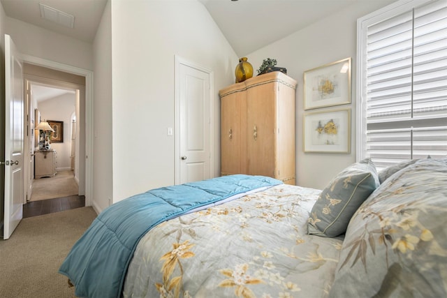 carpeted bedroom featuring lofted ceiling