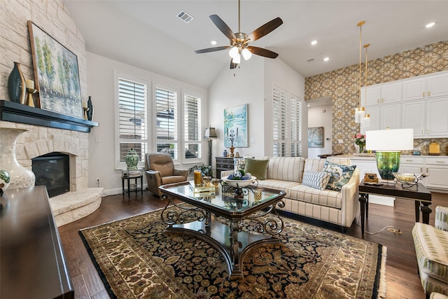 living room featuring high vaulted ceiling, a fireplace, dark hardwood / wood-style floors, and ceiling fan