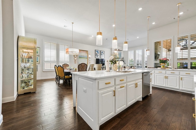 kitchen featuring a center island with sink, sink, stainless steel dishwasher, dark hardwood / wood-style floors, and white cabinetry