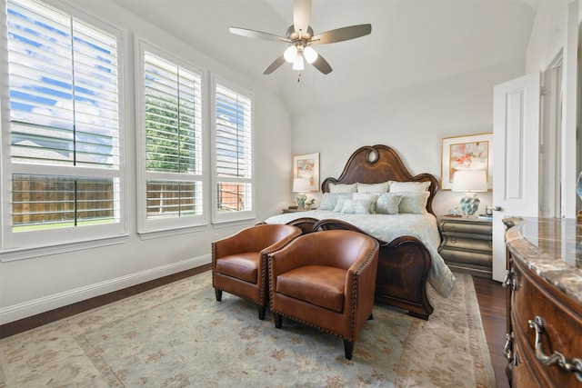 bedroom with ceiling fan, vaulted ceiling, and dark wood-type flooring