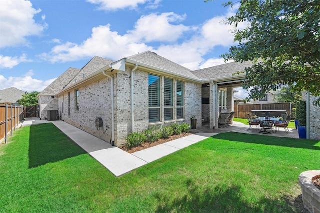 back of property with central AC, a yard, and a patio