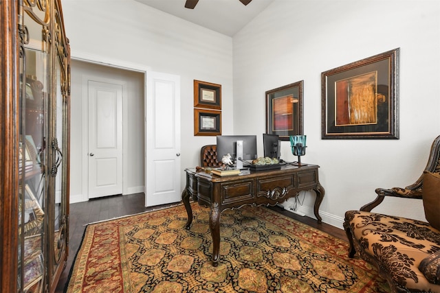 home office with dark hardwood / wood-style flooring, ceiling fan, and vaulted ceiling