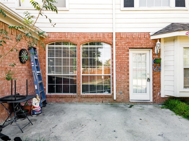 view of exterior entry with a patio