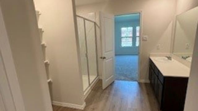 bathroom featuring hardwood / wood-style floors, vanity, and an enclosed shower