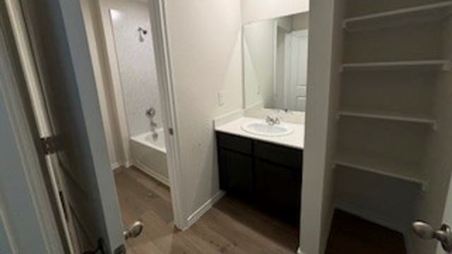 bathroom with vanity, tub / shower combination, and wood-type flooring