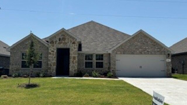 view of front of home featuring a garage and a front lawn