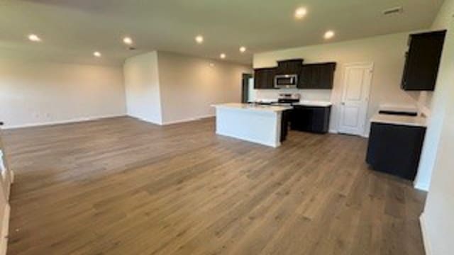 kitchen with a kitchen island, stove, and wood-type flooring