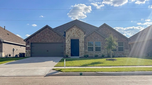 view of front of property with central AC, a front yard, and a garage