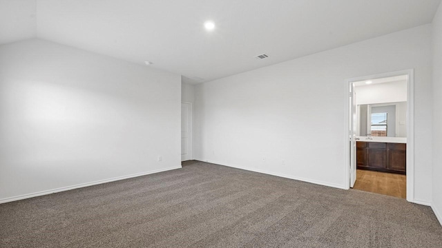 carpeted spare room featuring lofted ceiling