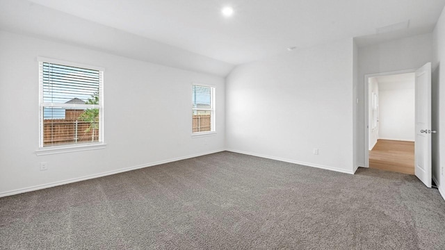 unfurnished room with lofted ceiling and carpet flooring