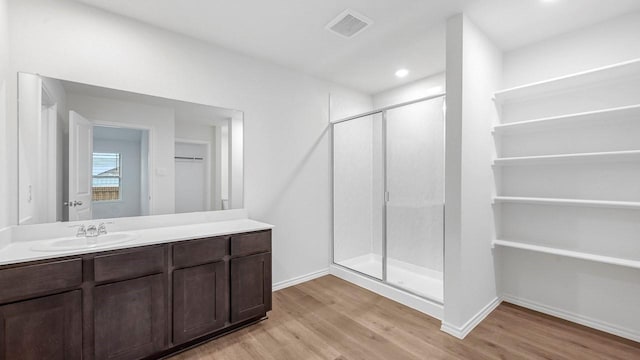 bathroom featuring hardwood / wood-style flooring, vanity, and a shower with door