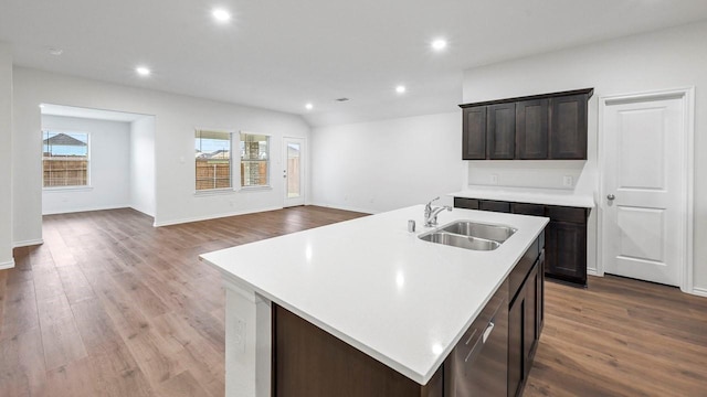 kitchen featuring a kitchen island with sink, dark brown cabinetry, light hardwood / wood-style floors, sink, and vaulted ceiling