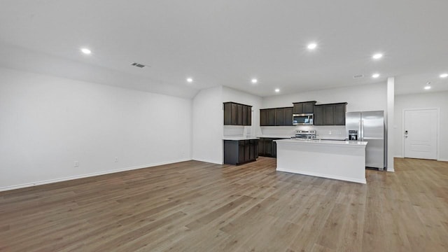 kitchen featuring a center island with sink, appliances with stainless steel finishes, and light hardwood / wood-style flooring