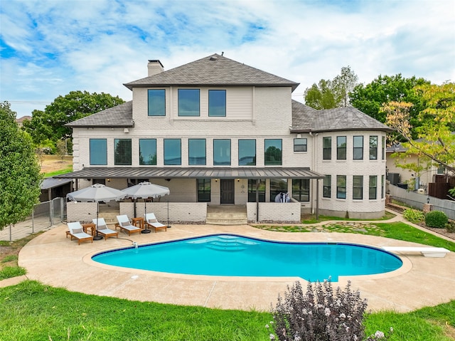 back of property featuring a fenced in pool and a patio