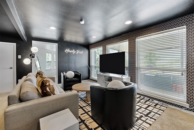 carpeted living room with beam ceiling, a wealth of natural light, and a textured ceiling