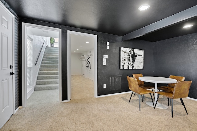 carpeted dining room featuring beam ceiling